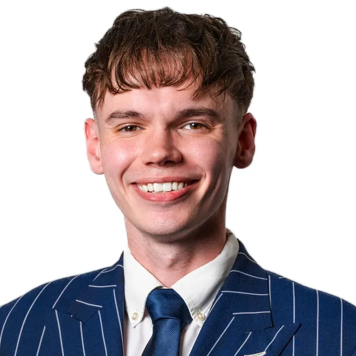 Ethan Mercer, smiling, in a navy pinstripe suit